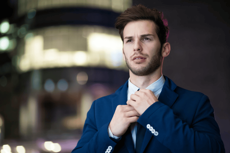 man adjusting tie